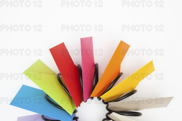 Propeller of colored envelopes on the white table
