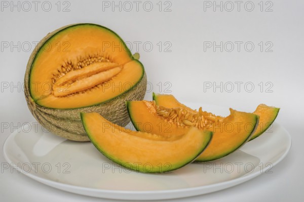 Cut cantaloupe with slices on white background