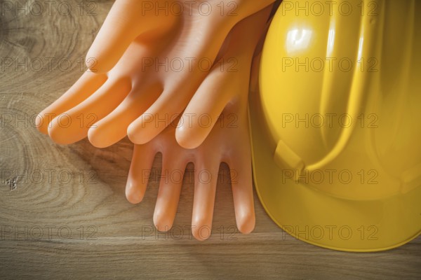 Safety building helmet electricians gloves on wood board