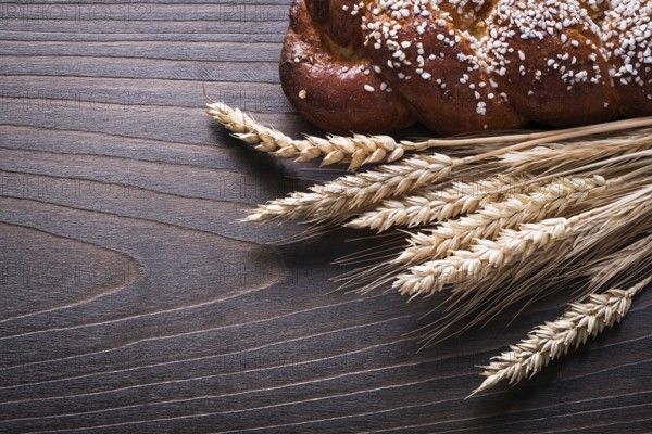 Sweet roll wheat rye ears on wooden background food and drink concept