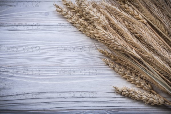 Bunch of golden wheat rye ears on wooden board food and drink concept
