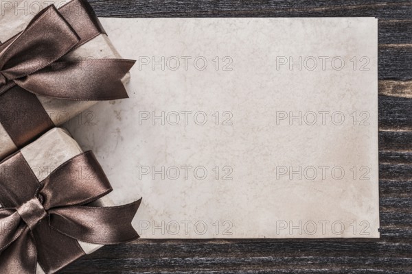 Wrapped boxed gifts paper on vintage wooden board holiday concept