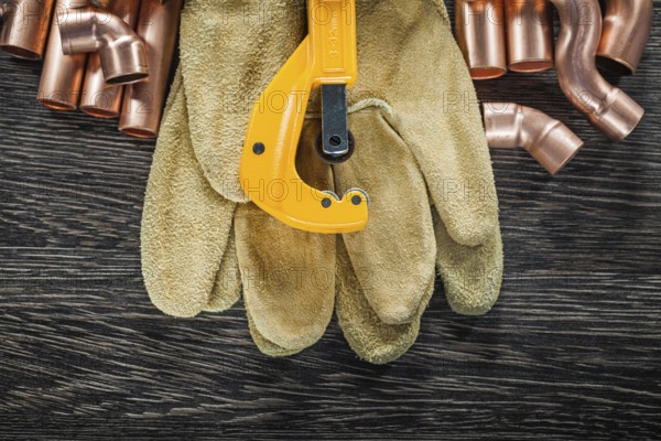 Plumbing copper water pipe scissors leather safety gloves on wooden board