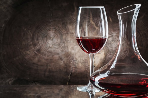 Very close up decanter and wineglass with red wine on vintage wooden background