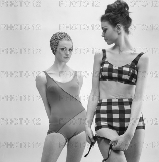 1960s swimsuit fashion. Two models are wearing the swimsuit and bikini fashion of 1963