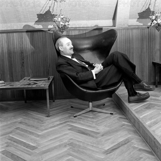 Simon Ove Christian Ogilvie Spies (1 September 1921 – 16 April 1984) was a Danish tycoon, best known for founding the charter airline Spies Rejser, and its airway company Conair of Scandinavia, and for his flamboyant lifestyle and womanising, including the procurement of sexual services from young women, the morgenbolledamer. Photographed sitting in an Egg armchair, designed by Arne Jacobsen for the Royal Hotel in Copenhagen. In 1958, the egg armchair became an instant success and has reached iconic status that is hard to beat. Egg armchairs were created using a technique that Jacobsen was the first to use. A durable inner shell of foam under the padding. 1961