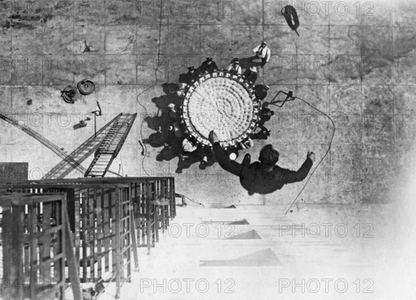 In the 1930s. A man jumps from a building into a life saving sheet. A device invented in 1887, and was until the 1980s used to save people by letting them jump from the upper floors of a burning buildings into the net, usually to the ground level. Firefighters believed that the practical height limit for successful use of life nets was about six stories, although in a 1930 Chicago fire, three people survived jumps from an eighth story building into a life net. 1930s