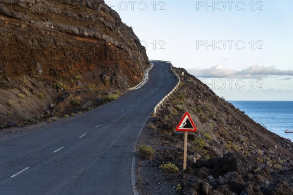 Empty road with risk of landslide traffic sign in a volcanic landscape in the Island of La Palma, one of the Canary Islands, in the Cumbre Vieja volcano area near Teneguia volcano