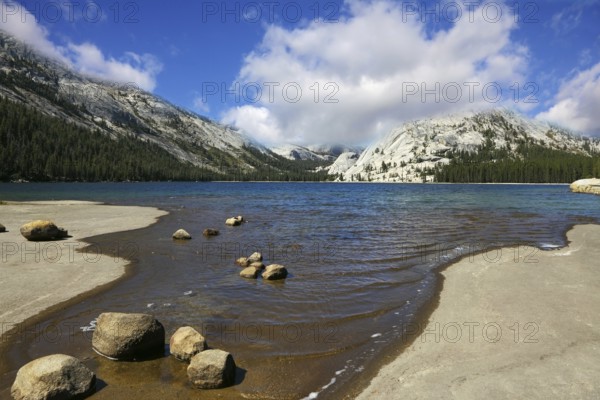 Flat coast of shallow lake in mountains of national park Yosemite
