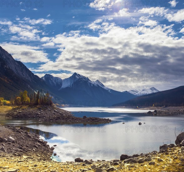 Canada, Alberta, Jasper Park. Lake Medicine. Great autumn day. The sun illuminates the snow-capped mountains. The concept of active, ecological and photo tourism