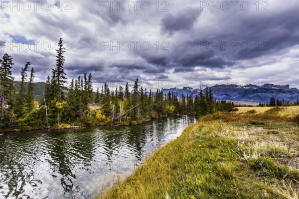The valley along the Pocahontas road. Beautiful cloudy day in the Rockies of Canada. Slender spruces reflected in shallow lake. Concept of active and photo-tourism