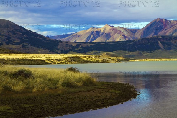 Huge lake with azure water, arid steppe of Patagonia and the steep slopes of cold mountains. Los Glaciares Natural Park in Argentina. The concept of active, extreme and photo tourism