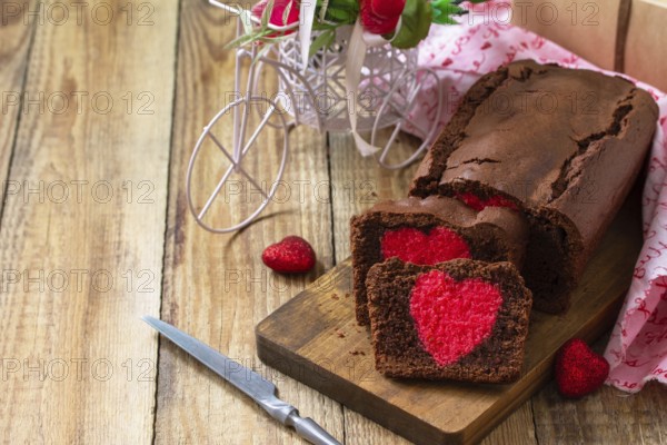 St. Valentine's Day, Birthday or Mother's Day dessert, homemade festive food. Homemade sweet chocolate brownie cake with red heart on a wooden rustic tabletop. Copy space