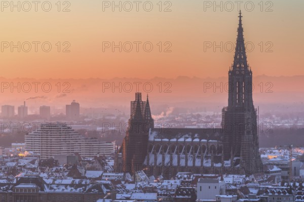 City Ulm in winter with fresh snow and fog. Mountains Alps in background with Minster