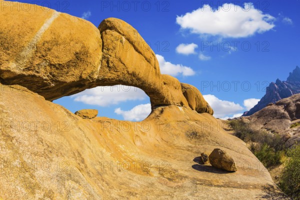Stone arch of Spitzkoppe. Concept of extreme and ecological tourism. Natural group of smooth bald granites among the Namib Desert, Namibia