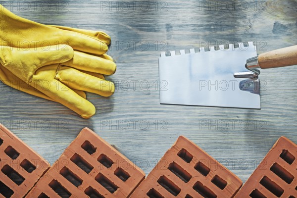Red bricks safety gloves bricklaying trowel building concept