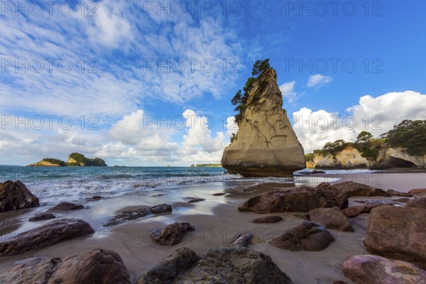 Huge boulders and picturesque rocks on a sandy beach. The New Zealand, North Island. Ocean low tide in Cathedral Cove at sunset. The concept of exotic, ecological and photo tourism