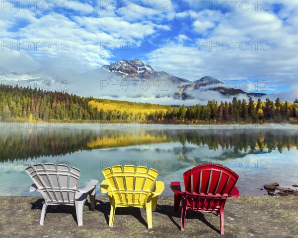 Rocky Mountains of Canada. Three comfortable multi-colored deck chairs stand by the Piramid lake. Concept of ecological, active and photo-tourism