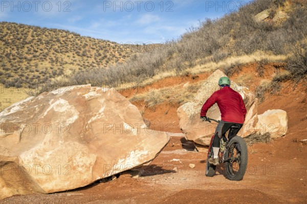Riding a fat bike on mountain desert trail in Red Mountain Open Space in northern Colorado, late fall scenery