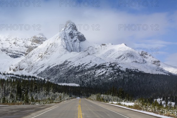 Beautiful autumn landscape scene in mountain in background in National Parkwest Canada with yellow belt on the road