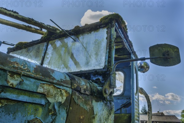 Old car rolled for scrapping in a meadow. Alsace, France