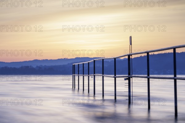 Twilight over the lake with railing, soft sky and calm atmosphere, lido, Litzelstetten, Lake Constance, Baden-Württemberg, Germany