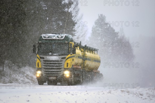 SALO, FINLAND, FEBRUARY 24, 2017: Colorful tank truck of Kuljetusliike K. Pekki transports goods along snowy, slippery road during a blizzard