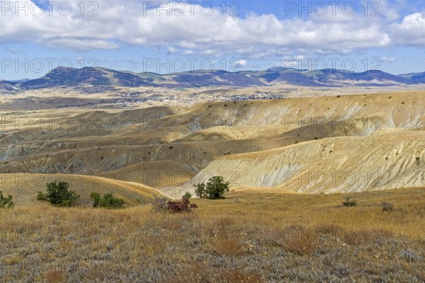Clay ravines with traces of soil erosion and weathering at the foot of Cape Meganom. Crimea, a sunny day in September