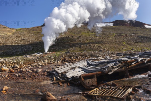 Emission of natural mineral thermal water, steam (steam-water mixture) from geological well in geothermal deposit area, geothermal power plant on slope of active Mutnovsky Volcano. Kamchatka Peninsula