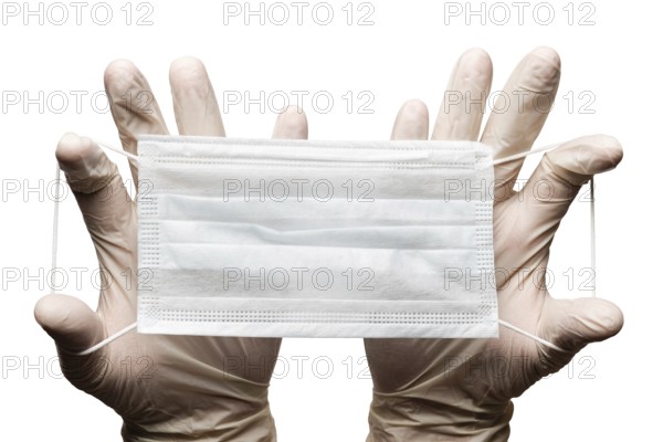 Doctor holding surgery medical face mask in hands in gloves isolated on white background. Medicinal concept protective clothing, equipment during corona virus, global pandemic, hygiene and health care