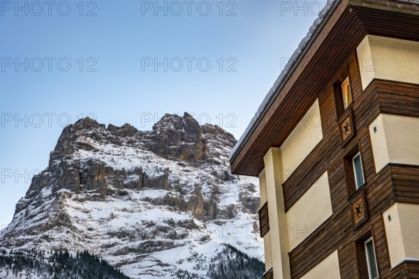 Snowcapped Mountain Peak Eiger at 3970 Meter High and a House in a Sunny Winter Day in Grindelwald, Bern Canton, Switzerland