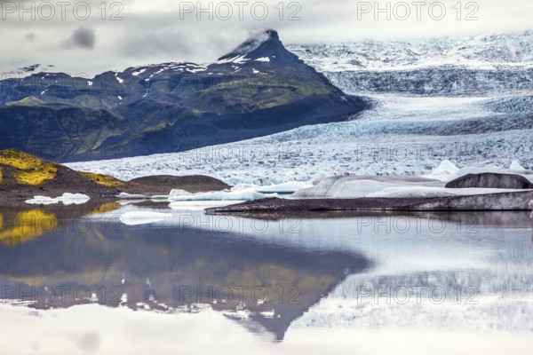 Glacier meltwater form a picturesque lake. The sunset over the Iceland's largest glacier Vatnajokull. The concept of extreme northern tourism
