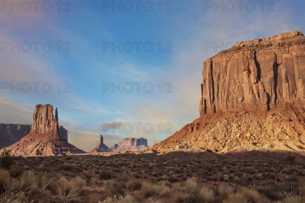 The famous cliffs Mittens in Monument Valley. The rocks - outcrops made of red sandstone. Bright multi-color sunset on the red stone valley. The concept of active, environmental and photo tourism