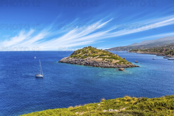 Holiday in Greece, island of Zakynthos. Bright blue sea water reflects coastal cliffs. Snow-white yacht sails along the rocky shores of the island. The concept of marine, active and resort recreation