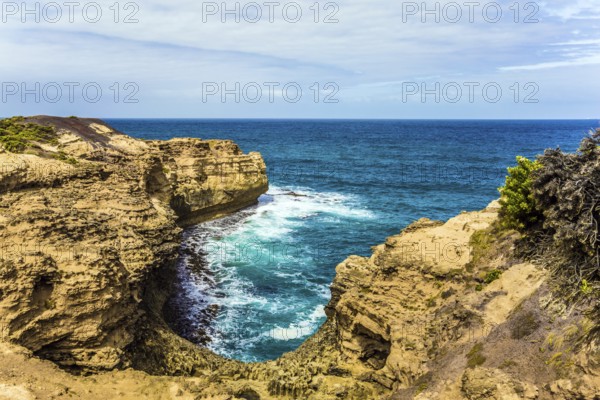The Great Ocean Road of Australia. Picturesque ocean bay with clear green water. The coastal cliffs are composed of sandstone. The concept of exotic, active and photo-tourism