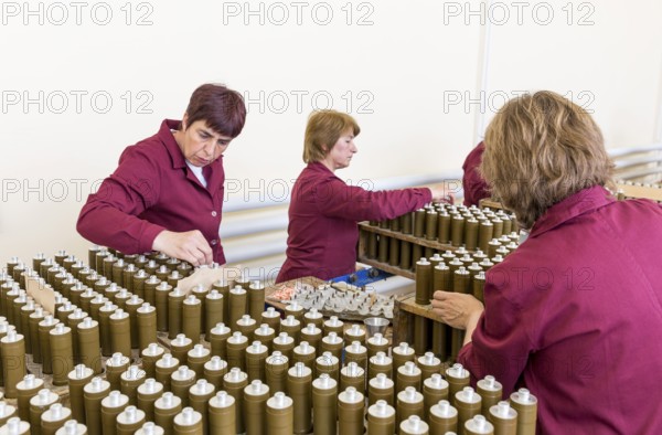 Sopot, Bulgaria - May 17, 2016: Female workers are checking explosive elements of anti tank rocket-propelled grenades (RPG, bazooka) near the assembly line in a munition factory