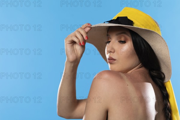 A teenager in a big beach hat holds a hand on a tanned shoulder