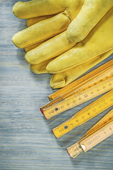 Wooden meter leather safety gloves on wood board construction concept