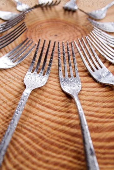 Series of different forks in a circle of pine board