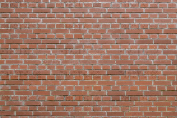 Bricks in an orange-red color in chain linked regulation to an old building in the Netherlands