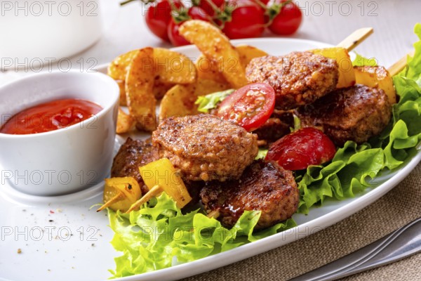 Meatballs skewers of tomato, paprika and baked potato quarters