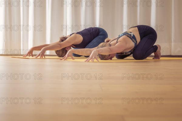 An image of two women doing yoga at home