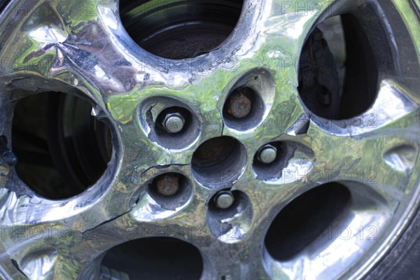 Cracked chrome wheel rim showing rust detail around bolt area