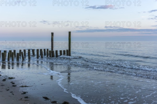 Beautiful Sunset at the seaside in the Netherlands with strong colours in the clouds and the water