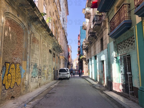 Street scene with colorful and old building on Havana. Urban scene with people and aged buildings in Old Havana. Cuba. February 21st, 2020