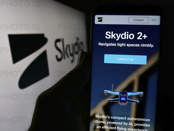 Stuttgart, Germany, 04-13-2024: Person holding cellphone with webpage of US drone manufacturing company Skydio Inc. in front of business logo. Focus on center of phone display