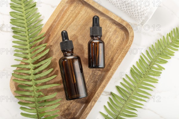 Essential oil bottle on wooden tray. Beauty, skin care, wellness. Yop view
