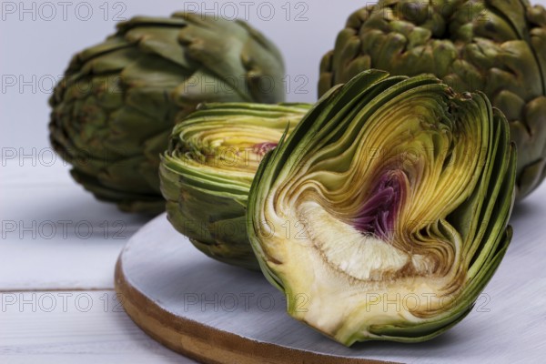 Close up of ripe organic artichokes on rustic wooden board