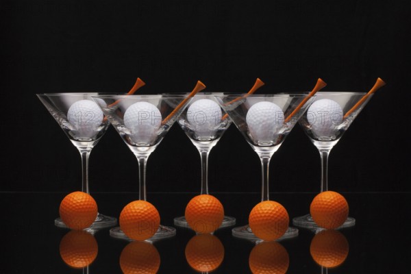 Five glasses of champagne with golf balls