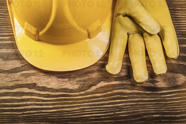 Leather safety gloves building helmet on wooden board construction concept
